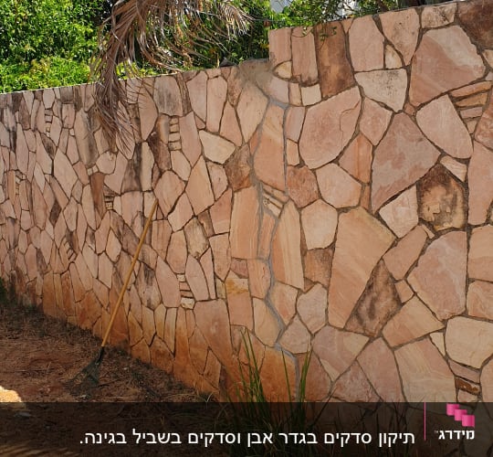 קיר אבן עם מגרפה על הקרקע